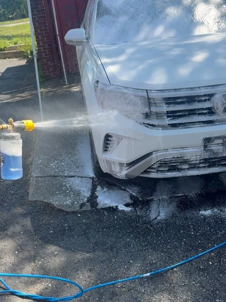 An SUV covered in thick cleaning foam during an Aquarius wash